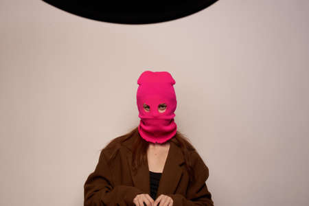 woman gangster with a gun in hand Lifestyle beige backgroundの写真素材