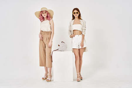 two girlfriends stand side by side fashion clothing glamor posingの写真素材