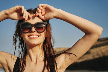 cheerful woman in sunglasses in a swimsuit on the beach sun islandの写真素材