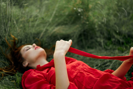 pretty woman in red dress lies on the grass in the field nature fresh air