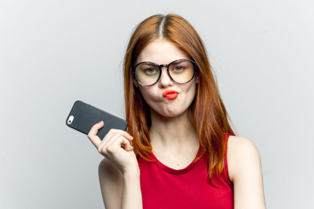 emotional red-haired woman with a phone in her hands communicating gadgetの写真素材