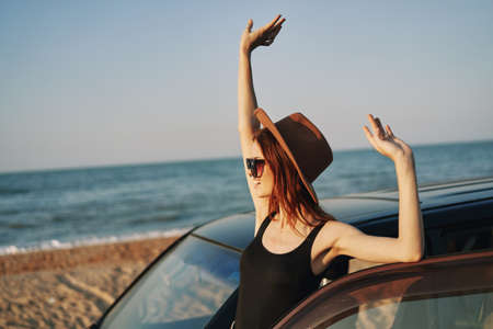 woman on the beach is with a car wearing sunglasses travelの写真素材