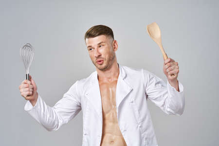 muscular man in white shirt holding kitchen appliancesの写真素材