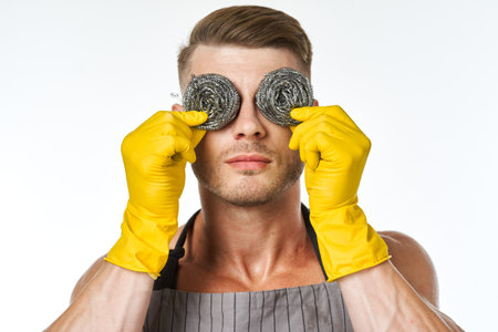 a man in a gray apron wearing rubber gloves cleaning washing
