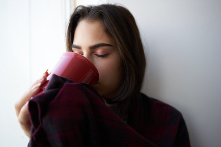 women near the window cup in hands emotions