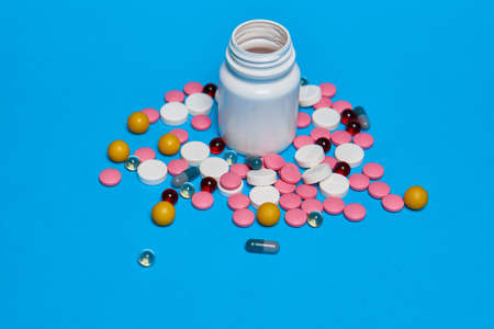 multicolored pills Pharmaceuticals medicines syringe blue backgroundの写真素材