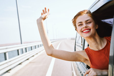 cheerful woman peeking out of the car window trip road travel