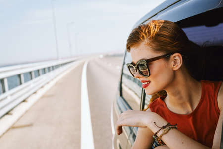 pretty woman in sunglasses rides in a travel carの写真素材