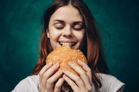 woman eating hamburger fast food snack close-upの写真素材