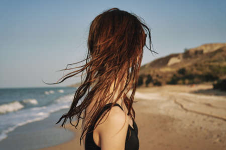 pretty woman in black swimsuit posing tanning tropicsの写真素材