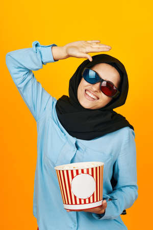 woman in black hijab entertainment going to the cinema popcorn isolated backgroundの写真素材