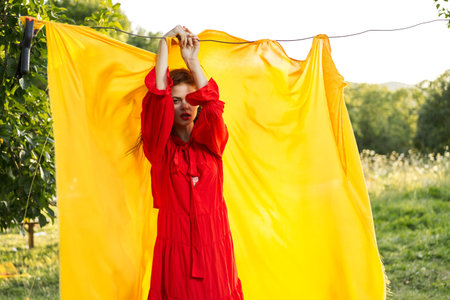 emotional woman in red dress nature yellow background posing