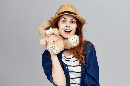 cheerful woman in a hat with a teddy bear gift toy