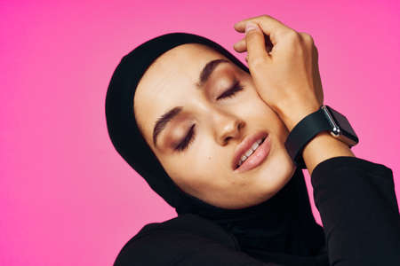 muslim woman with smart watch technology gadget pink backgroundの写真素材