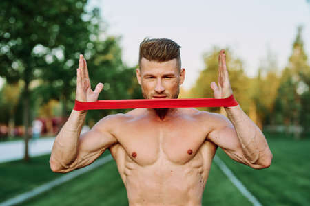 athletic man with a pumped up body in the park exercise fitnessの写真素材