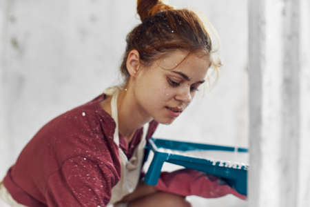 cheerful woman paints a room in a house renovation interiorの写真素材