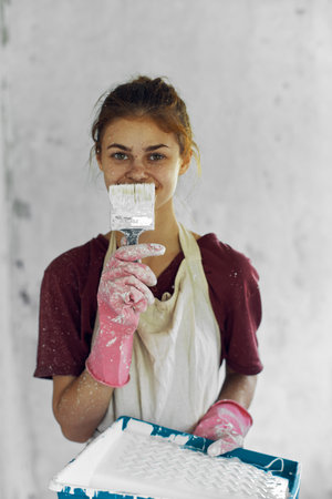 woman painter with brush paints in room decoration home renovation