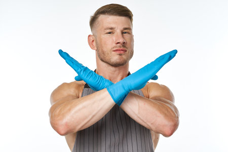 man in blue rubber gloves in an apron gesturing with his hands