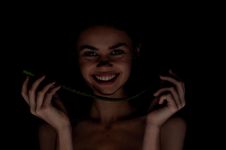 woman with bare shoulders clear skin aloe organic dark backgroundの写真素材