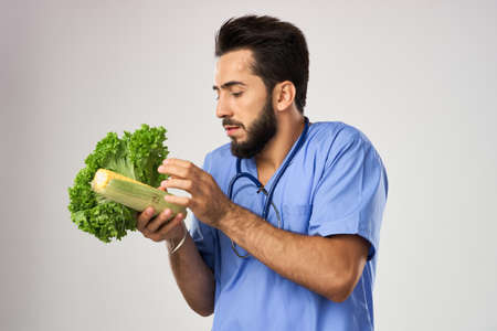 Cheerful dietitian doctor with vegetables in hands stethoscope treatmentの写真素材