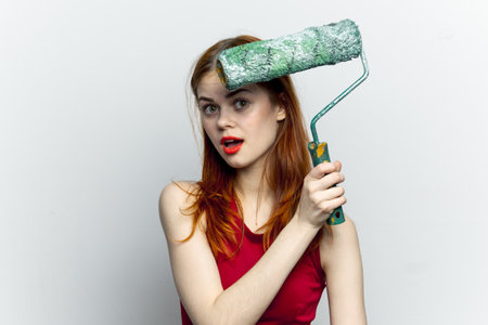pretty woman in red t shirt paint roller houseworkの写真素材