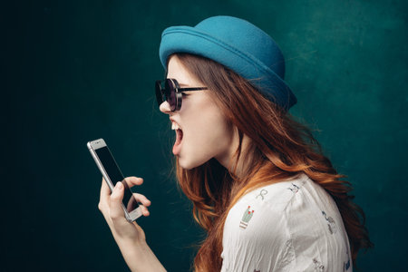 fashionable woman in blue hat with phone in hands communication technology