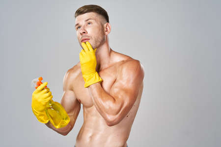 muscular man wearing rubber gloves posing homeworkの写真素材