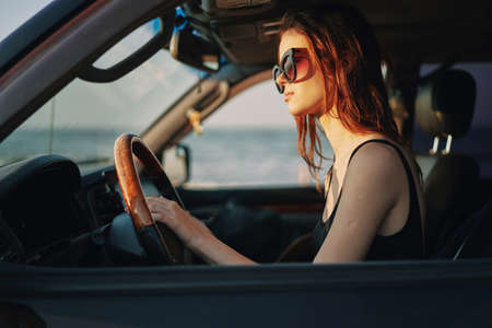 pretty woman in sunglasses driving a car tripの写真素材