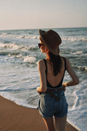 woman walking on the beach hat travel vacation sunの写真素材