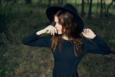 woman in the forest in a black hat gothic style Witch costumeの写真素材
