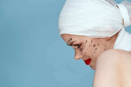 beautiful woman in blue gloves syringe in hands contour on the face lifting studio lifestyleの写真素材