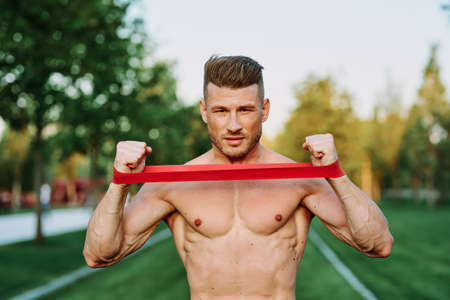 athletic man with a pumped up body in the park exercise fitnessの写真素材