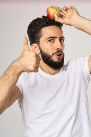 bearded man in white t-shirt apples holding healthy food