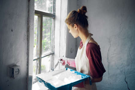 woman in aprons paints window home renovation interiorの写真素材