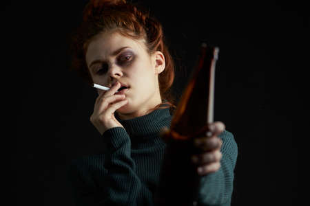 woman with cigarette bottle of alcohol bruises under eyes problems depressionの写真素材