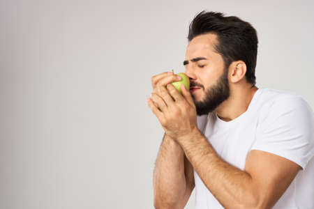 bearded man in white t-shirt apple health proper nutritionの写真素材