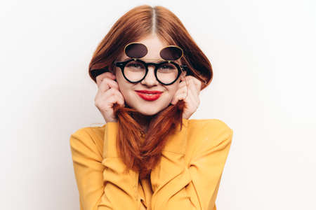 glamorous woman sunglasses red hair light backgroundの写真素材