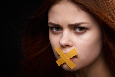 woman with bare shoulders taped mouth banned from dietの写真素材