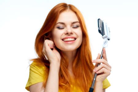 pretty red haired woman hair care posing light backgroundの写真素材