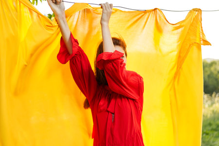 emotional woman in red dress nature yellow background posing