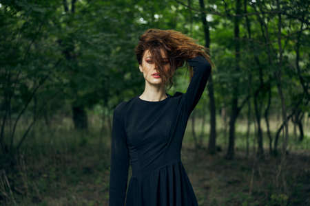 woman in black dress in the forest Halloween Witch costumeの写真素材