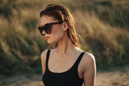 woman in sunglasses eating chips in nature sunの写真素材