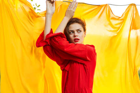 emotional woman in red dress nature yellow background posingの写真素材
