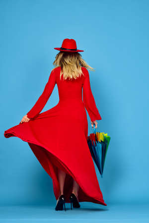 woman in red dress multicolored umbrella blue backgroundの写真素材