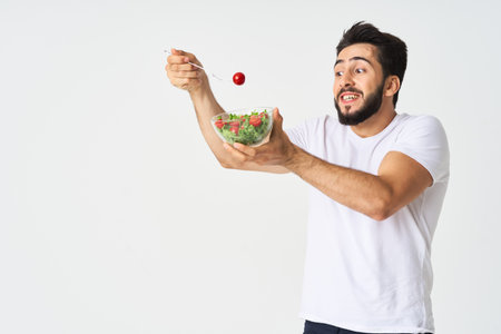 a man in a white t-shirt in a plate with salad a snack healthy food