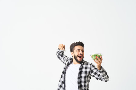 man in plaid shirt eating salad healthy foodの写真素材