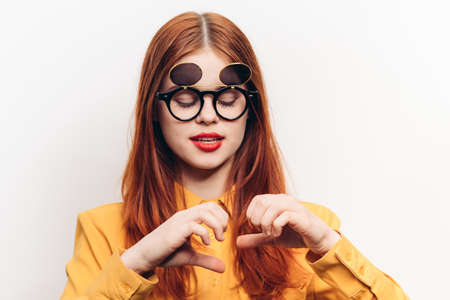 red-haired woman wearing sunglasses posing fashion light backgroundの写真素材