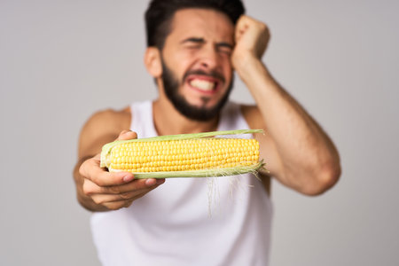 Cheerful man with corn in hand fresh vegetables health isolated background