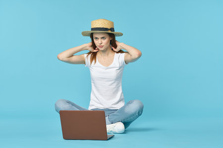 woman with laptop sit on floor learning internet technology blue background