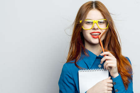 business woman with notepad and pencil wearing yellow glasses office professionalの写真素材